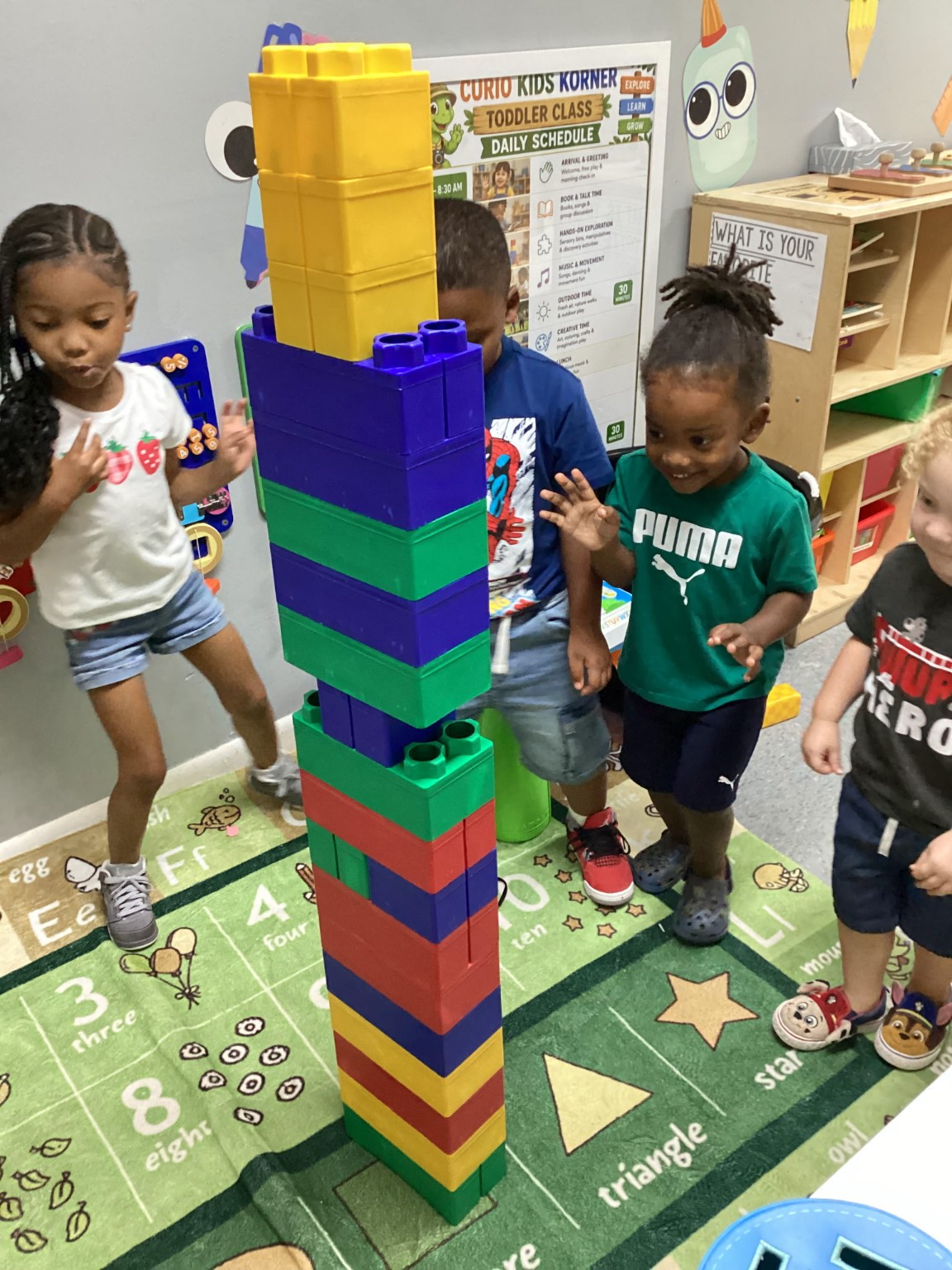Young World children building together with large blocks